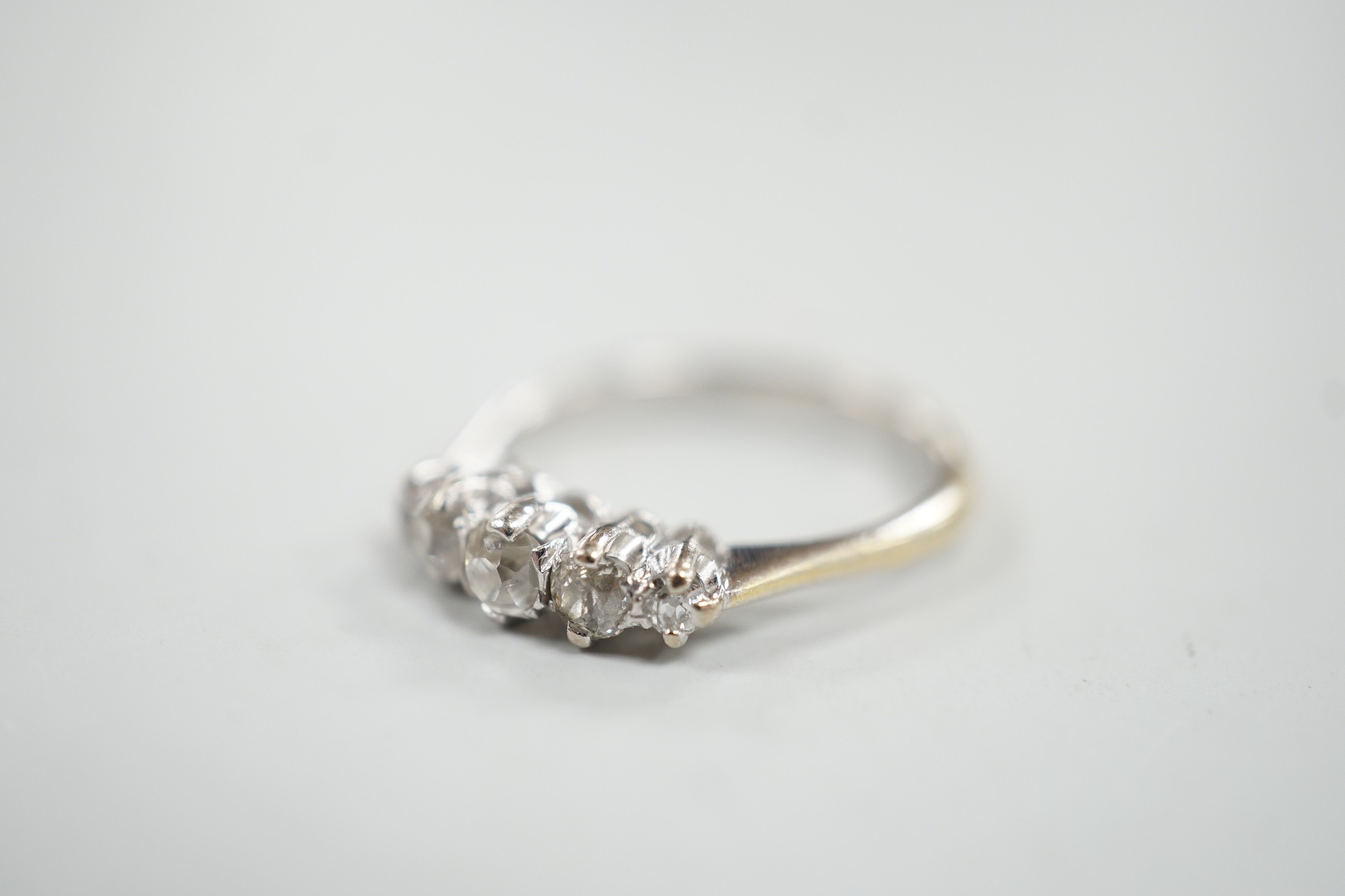 A 1970's 18ct white gold and graduated five stone diamond ring, size L/M, gross weight 3 grams.